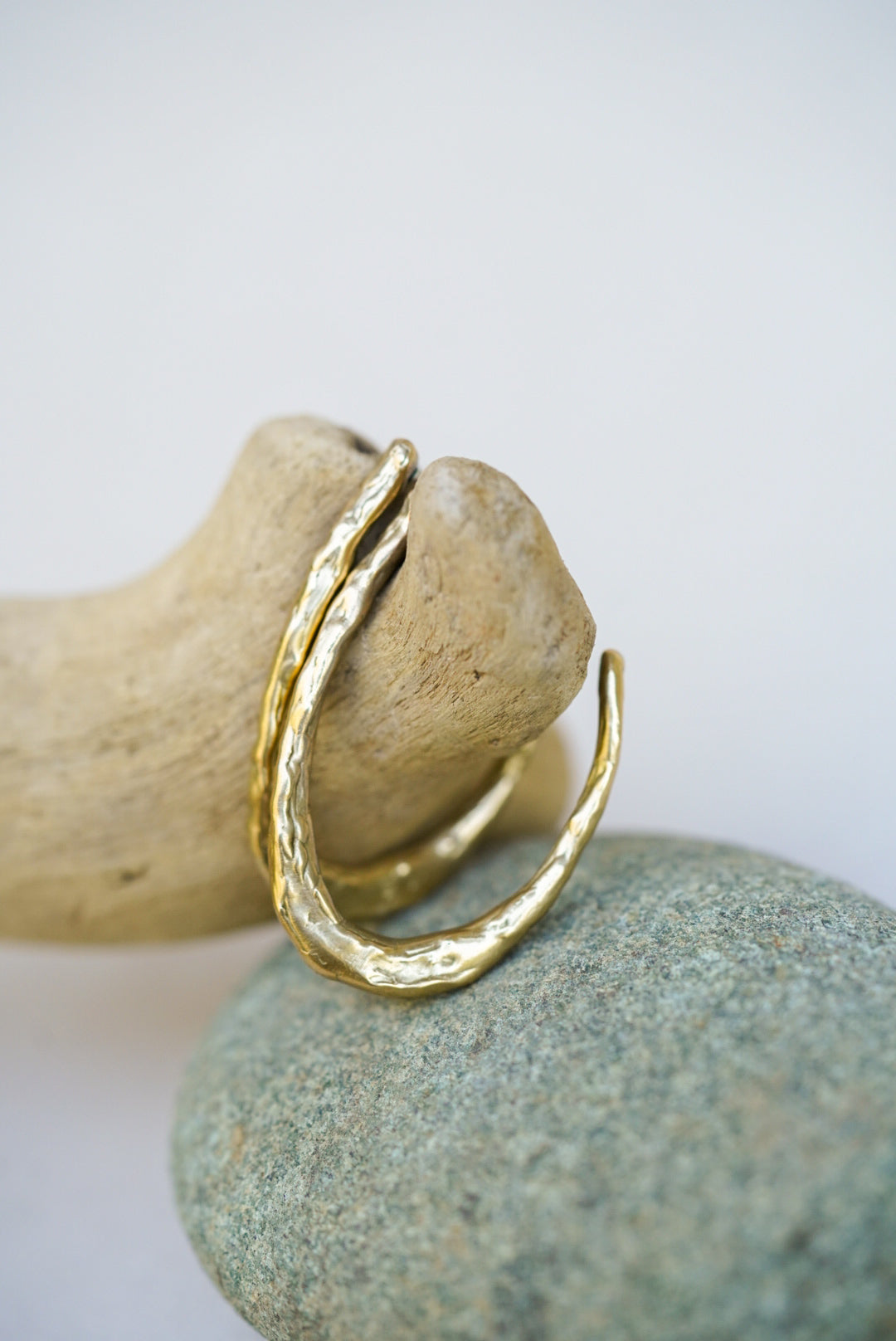Gold earrings on a rock with a white background