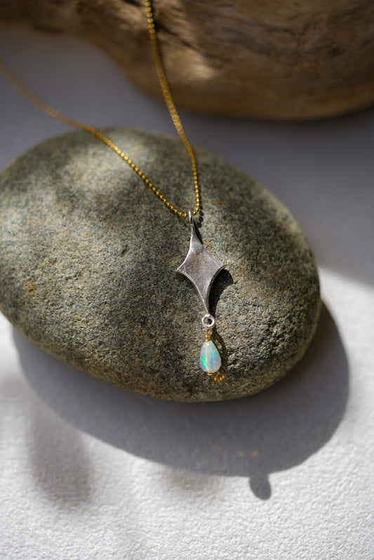Necklace with a pendant and opal on a stone surface