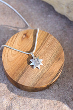 Load image into Gallery viewer, Silver necklace with a star-shaped pendant on a wooden block
