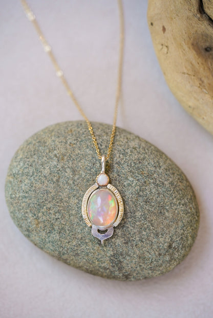 Opal pendant necklace on a pebble