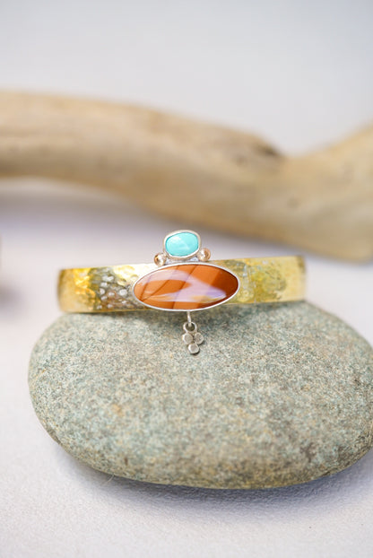 statement cuff with jasper and turquoise on a river rock