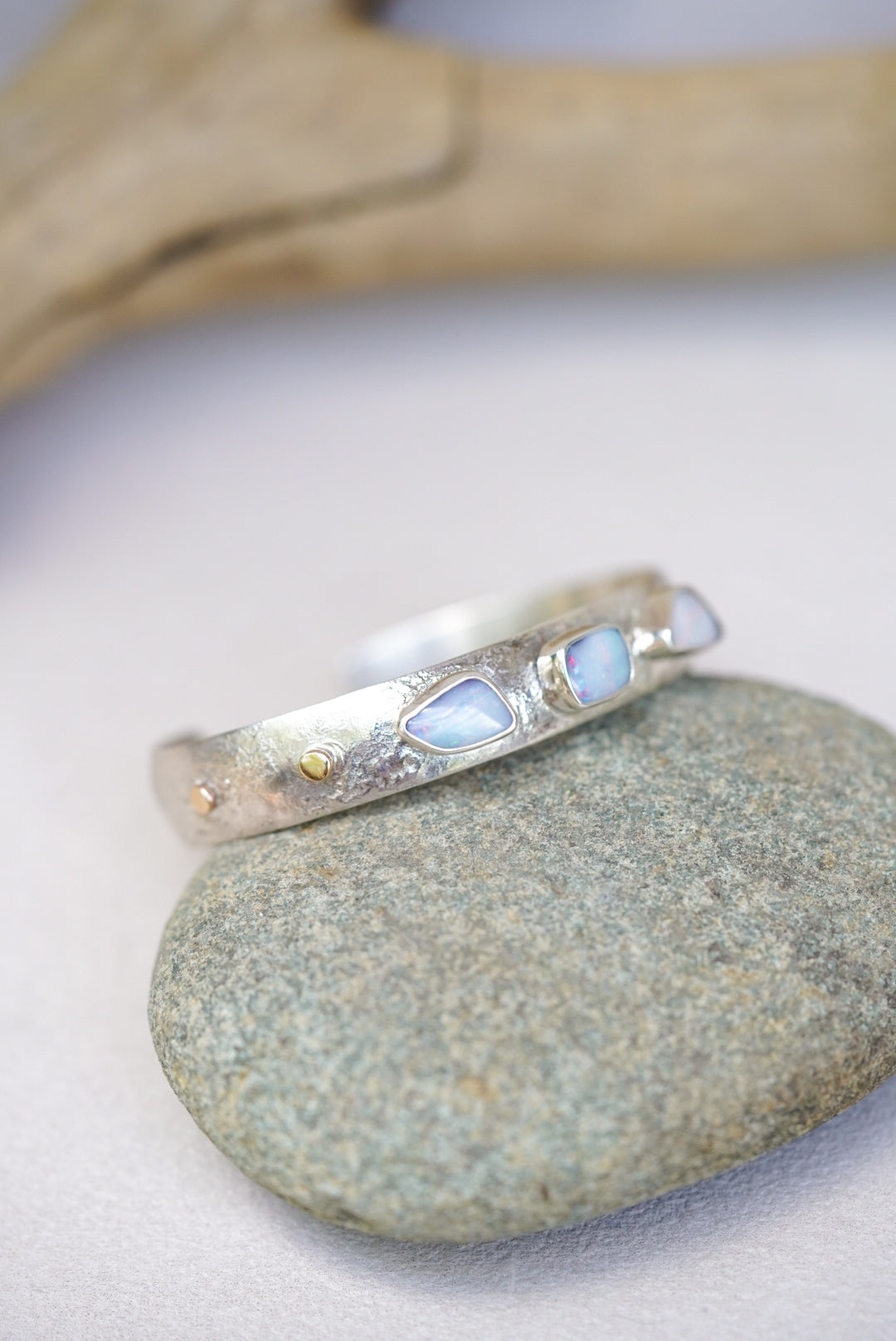 Silver bracelet with opal stones on pebble