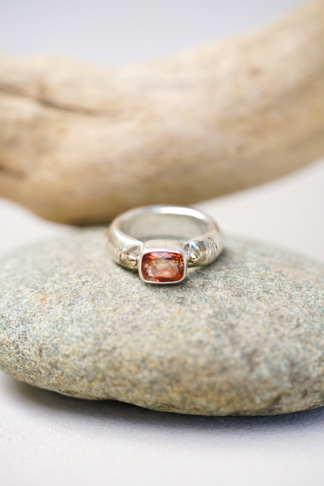 Sunstone silver ring on a piece of river rock