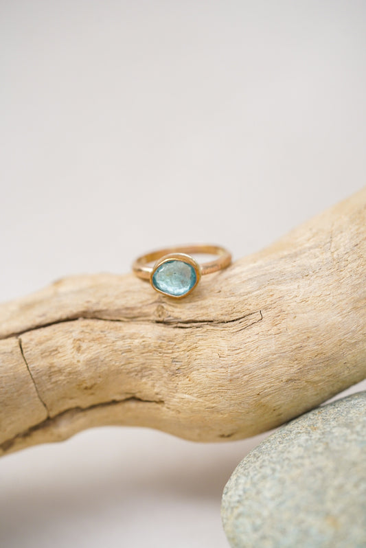 Aquamarine gold ring on a piece of driftwood