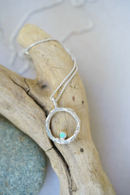 Silver necklace with a opal on a piece of driftwood