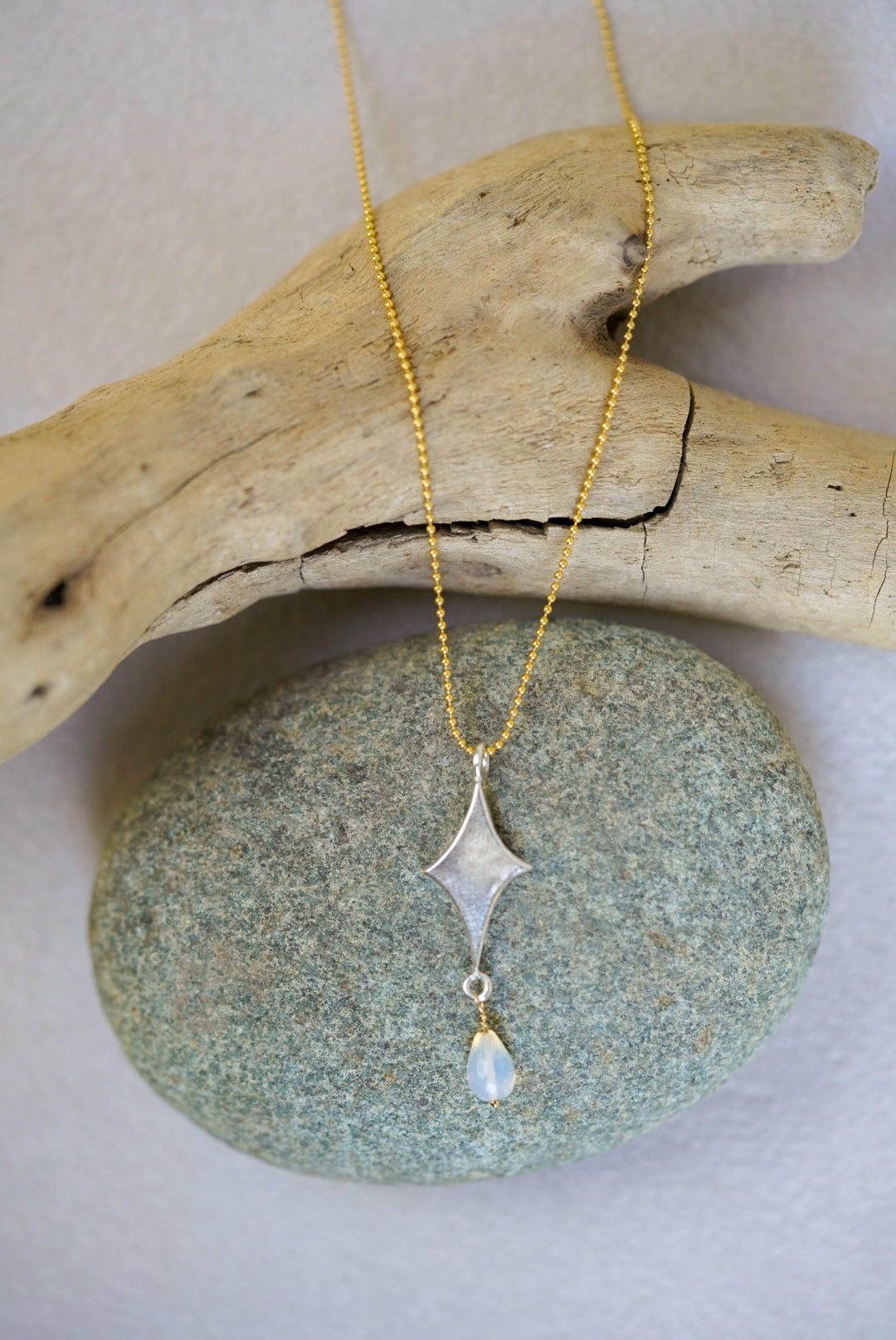 Necklace with a pendant on a stone and driftwood