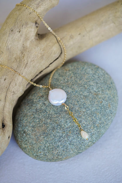 Necklace with a white pendant on a stone surface