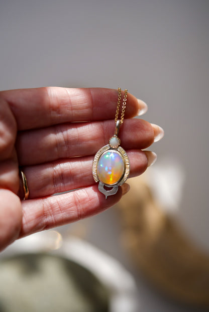 hand holding a large opal pendant