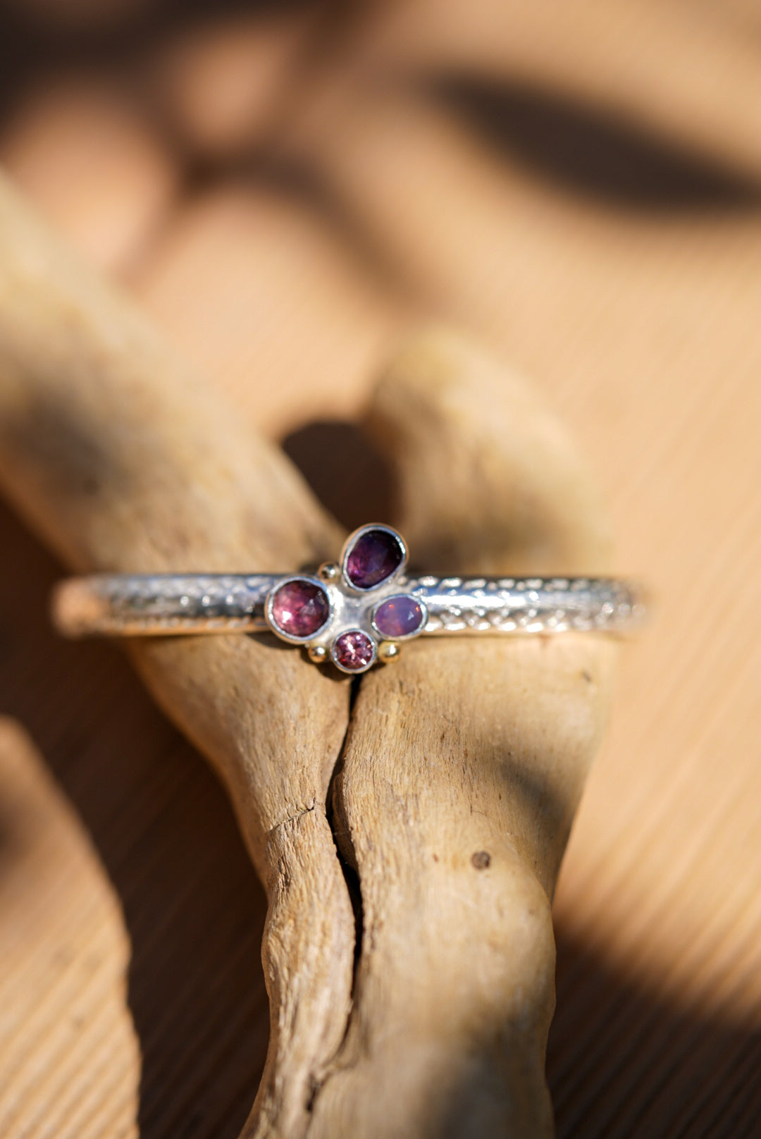 Silver cuff with gemstones on a wooden surface