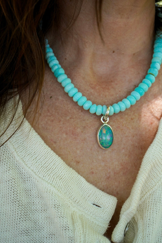 Baby blue beaded necklace with a opal pendant worn by a person