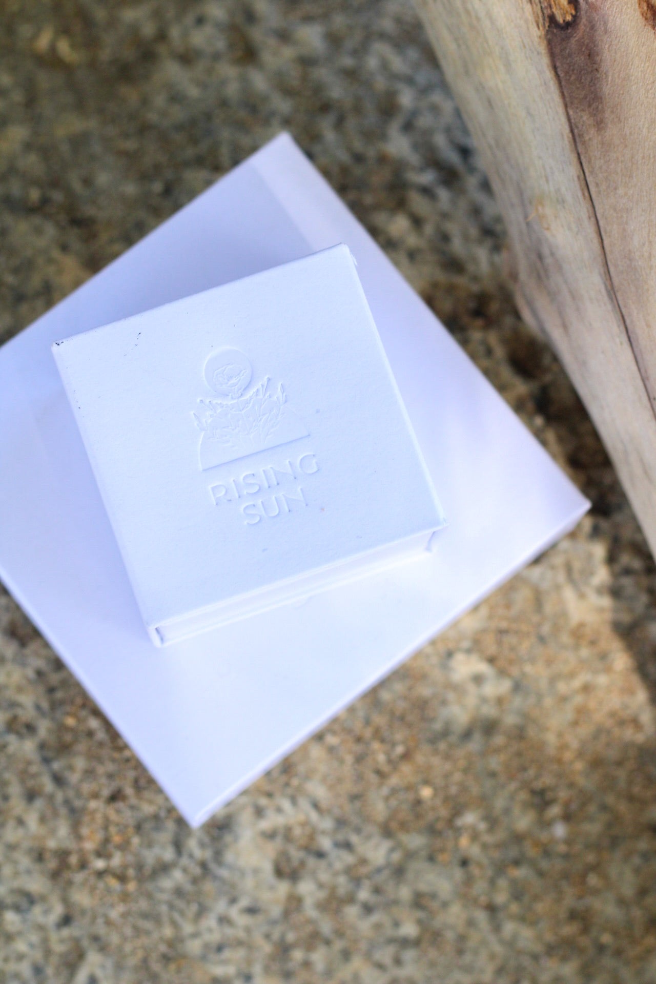 Rising Sun Jewelry boxes. White stacked together with a sandy backdrop.