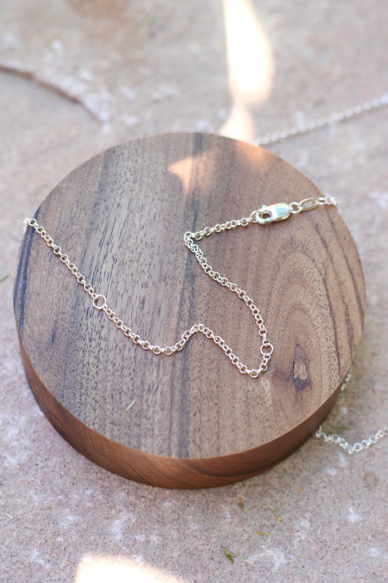 Silver chain necklace on a wooden surface