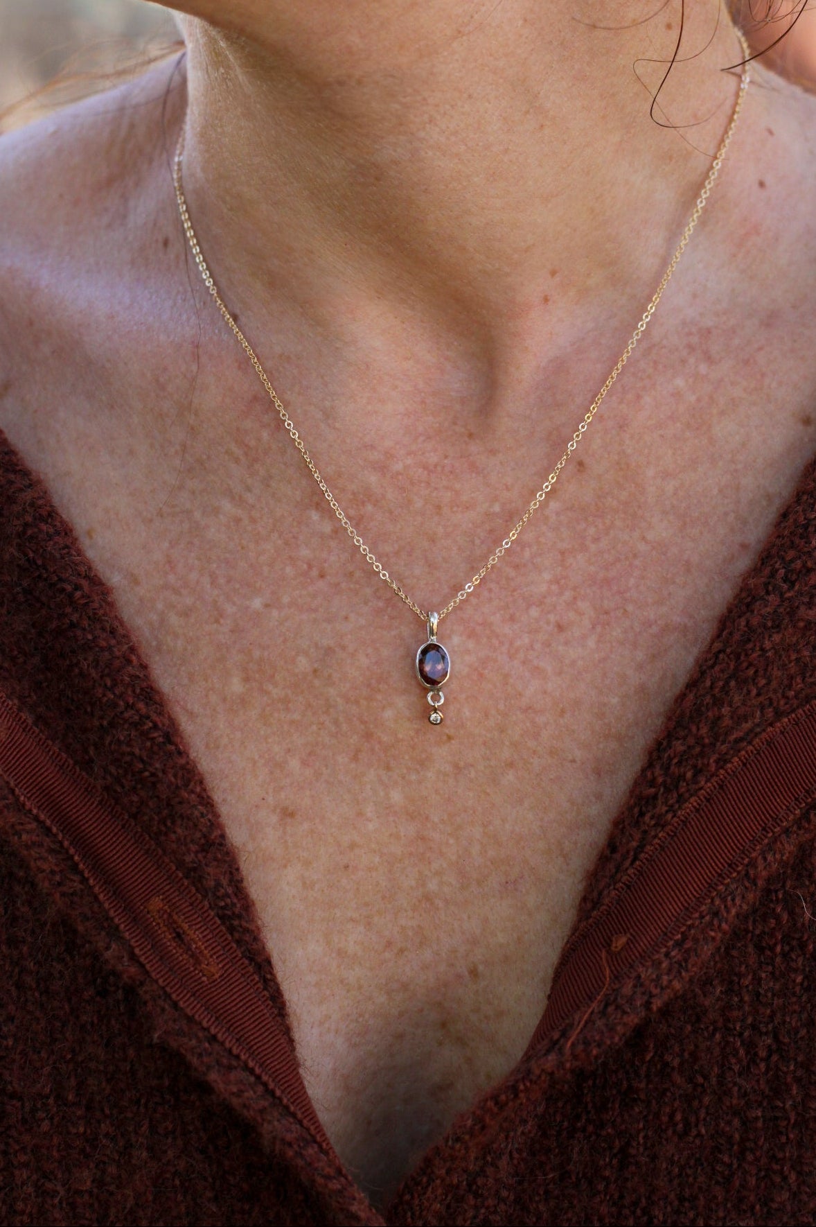 Necklace with a pendant worn by a person, close-up view.