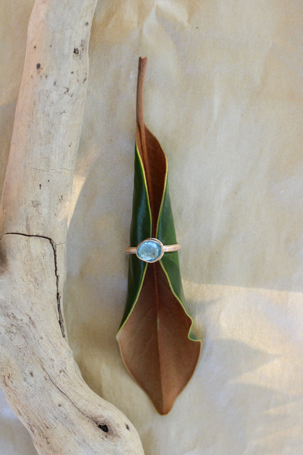 Gold ring with a aquamarine gemstone on a leaf-shaped stone