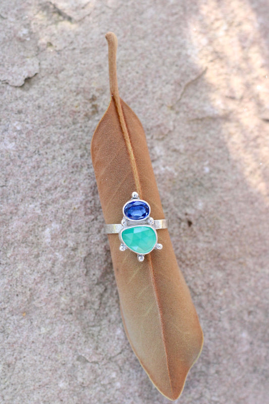 cobalt blue kyanite and green chalcedony ring on a brown leaf on a neutral background
