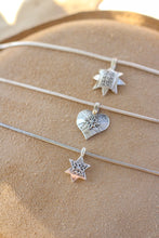 Load image into Gallery viewer, Silver necklaces with star and heart pendants on a beige surface
