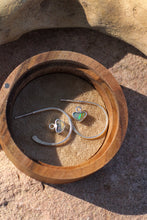 Load image into Gallery viewer, Silver hoop earrings with heart shaped opal charms in a wooden box on a stone surface
