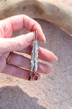 Load image into Gallery viewer, Hand holding a pair of silver earrings with gemstones against a neutral background
