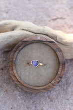 Load image into Gallery viewer, Heart-shaped opal ring with a purple stone in a wooden box on a sandy surface
