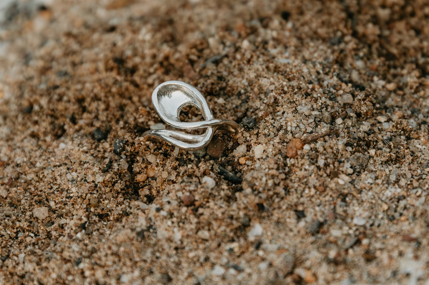 Silver ring on a sandy surface