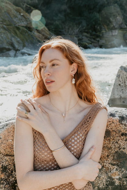 Woman with full jewelry on a rocky beach